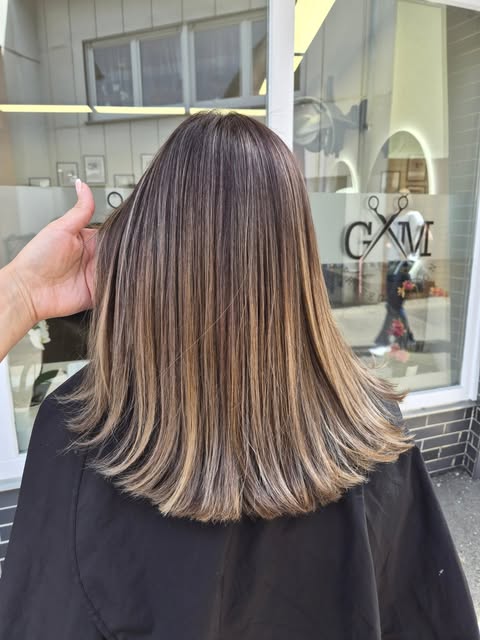 Strähnen-Färbung mit GM-Salon-Logo im Hintergrund